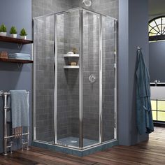 a walk in shower sitting on top of a wooden floor