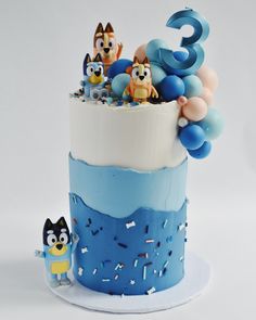 a blue and white cake with cartoon figures on top