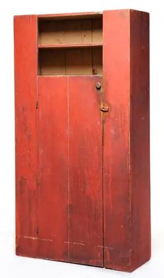 an old red wooden cabinet with two shelves on one side and a door to the other