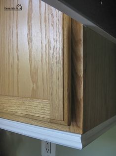 the corner of a kitchen cabinet that has been painted white and is being replaced with wood