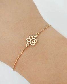 a woman's arm wearing a gold bracelet with an evil eye charm on it