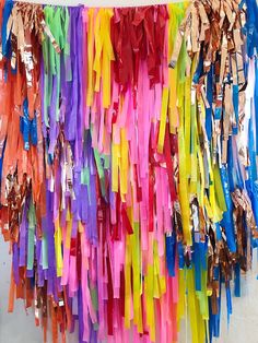 colorful streamers hanging from the ceiling in an art room or office area with metallic foil on them