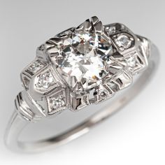 an antique style diamond ring with filigrees and baguetts set in white gold