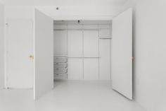 an empty closet with white walls and shelves