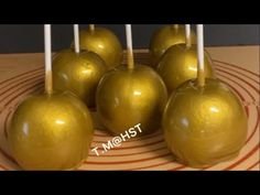 some golden apples are sitting on a plate with candles in the shape of an apple