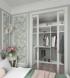 a bedroom with green and white wallpaper and closets