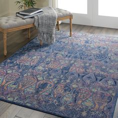 a blue rug with an ornate design on the floor in front of a wooden bench