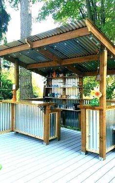 an outdoor bar made out of metal and wooden planks with shelves on the side