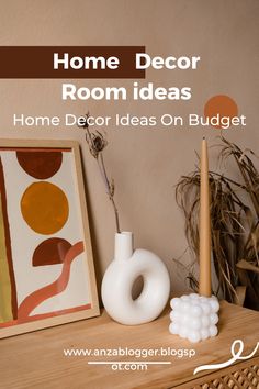 a white vase sitting on top of a wooden table next to a painting and brush