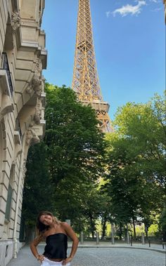 a woman standing in front of the eiffel tower