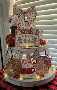 a three tiered cake decorated with gingerbread cookies and candy canes on top