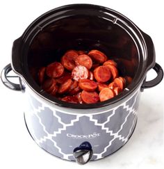 a crock pot filled with hot dogs on top of a table