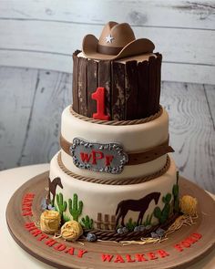 a three tiered cake decorated with cowboy themed decorations