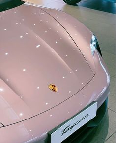 a pink sports car parked in a showroom