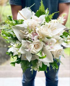 a man holding a bouquet of white flowers