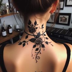 a woman's back neck tattoo with roses on it