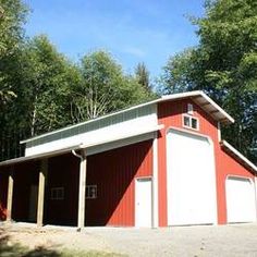 a red and white garage sitting in the middle of a forest