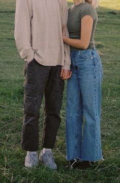 two people standing next to each other in the grass