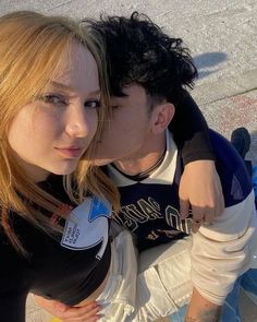 a man and woman sitting next to each other on top of a skateboard ramp