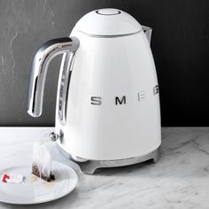 a white toaster sitting on top of a counter next to a plate