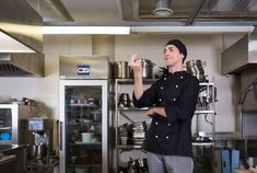 a man standing in a kitchen with pots and pans