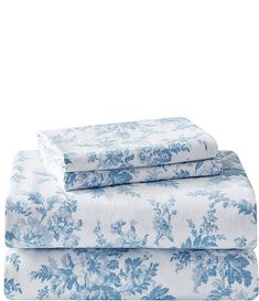 the blue and white sheets are folded on top of each other, with floral designs