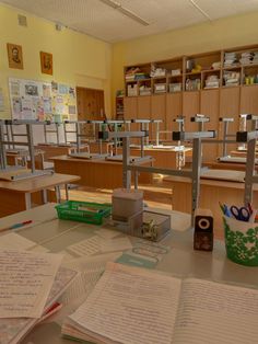 an empty classroom with lots of desks and books on top of the desk are full of papers