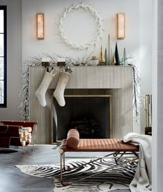 a living room decorated for christmas with stockings hanging on the fireplace and zebra print rug