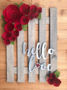 a wooden sign that says hello love with red flowers on the front and back side