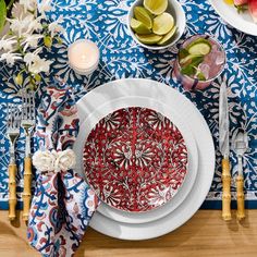 a table set with plates, silverware and flowers