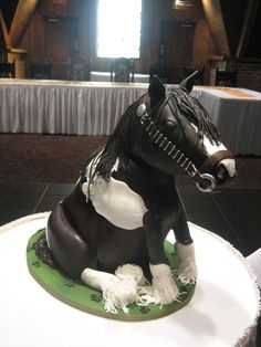 a black and white horse statue sitting on top of a green plate next to a table