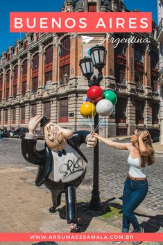 a woman standing next to a street light with balloons in the shape of cartoon characters