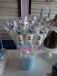 a table with cake pops and cupcakes in the shape of penguins on them