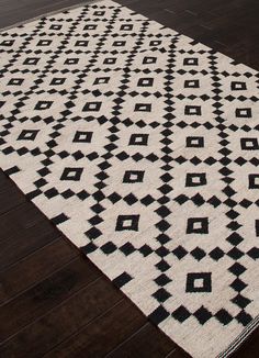 a black and white rug on a wooden floor