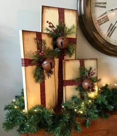 christmas decorations on top of a mantle with a clock in the background