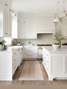 a kitchen with white cabinets and wooden floors is featured on the instagram page for an interior design firm