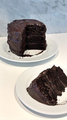 two white plates with slices of chocolate cake on top of each other and one slice missing