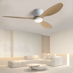 a living room with white furniture and a ceiling fan in the middle of the room