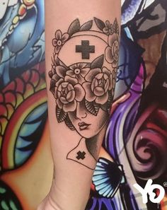 a woman's arm with flowers and a cross on it