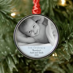 a baby's first christmas ornament hanging from a tree