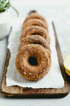 doughnuts are arranged on a wooden cutting board