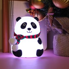 a panda bear lamp sitting on top of a table next to a christmas ornament