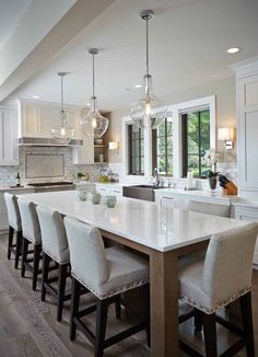 a large kitchen with an island in the middle and lots of stools around it