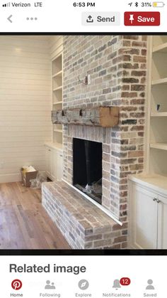 an empty room with a brick fireplace and shelves