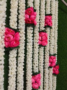 pink and white flowers are arranged in rows on the grass, along with green leaves