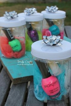 four jars with different items in them on a wooden table, one is filled with yarn and the other has a bow