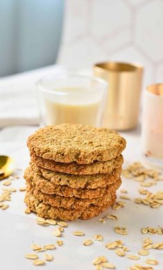 oatmeal cookies stacked on top of each other next to a glass of milk