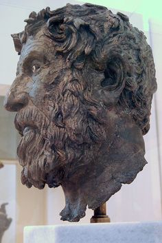 a statue of a man's head is shown in front of a white wall