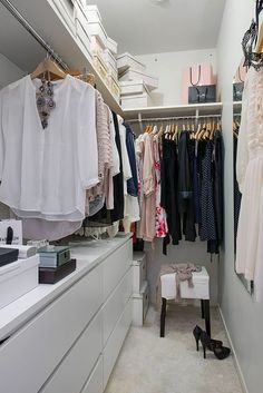 an organized closet with clothes and shoes on hangers, drawers, and other items