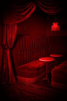 a red room with two tables and a bed